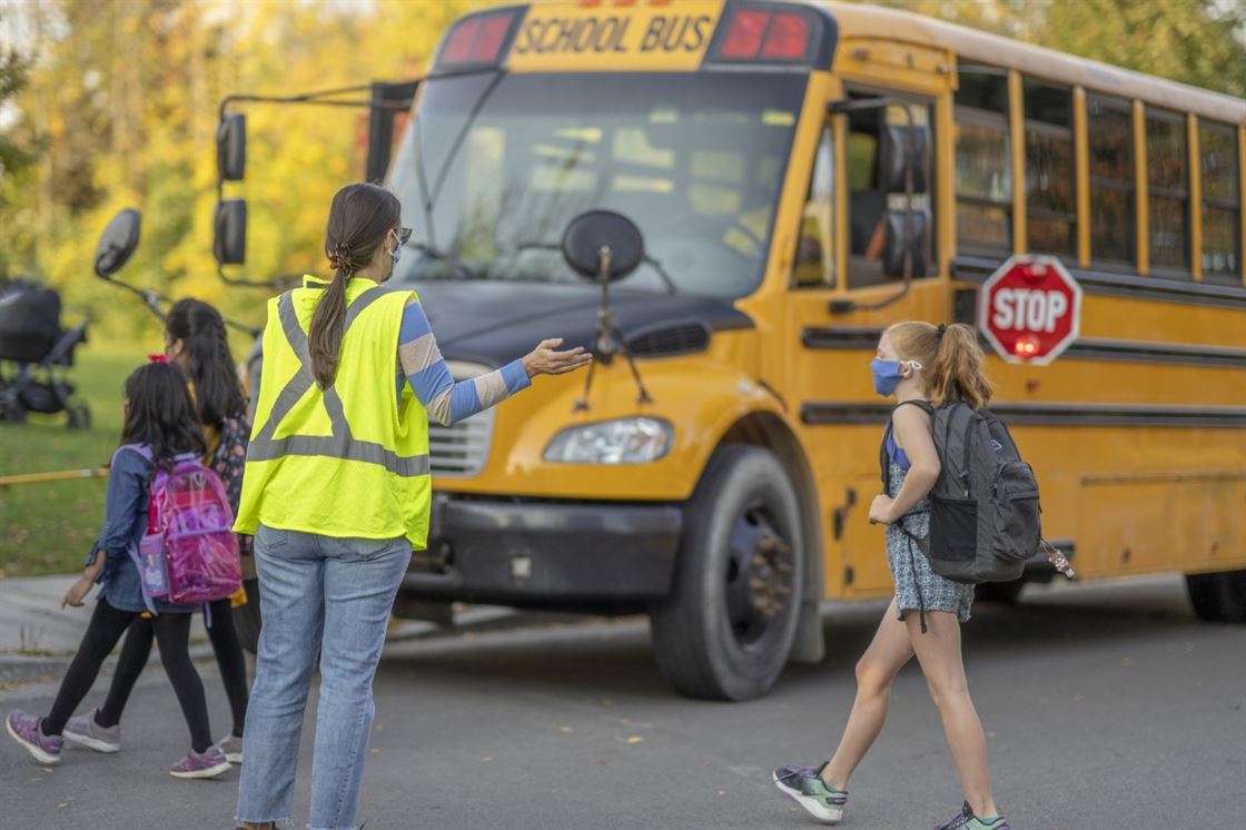 A group of people walking next to a school bus

Description automatically generated